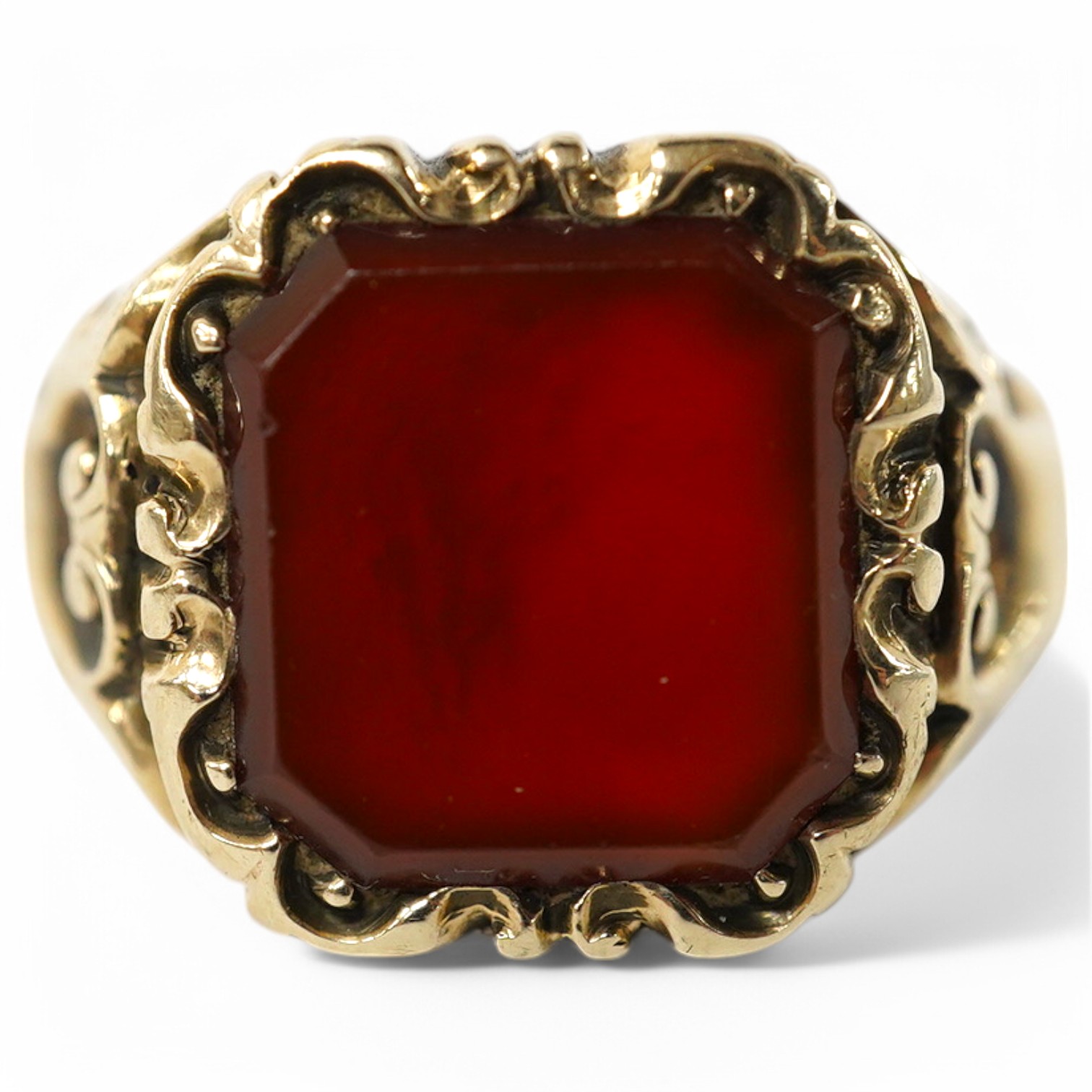 A carved yellow metal and carnelian set signet ring, size I/J, gross weight 5.1 grams. Condition - fair